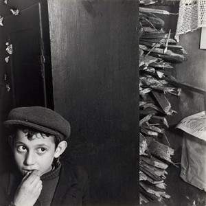 Roman-Vishniac---Boy-with-kindling-in-basement-dwelling,-Krochmalna-Street,-Warsaw